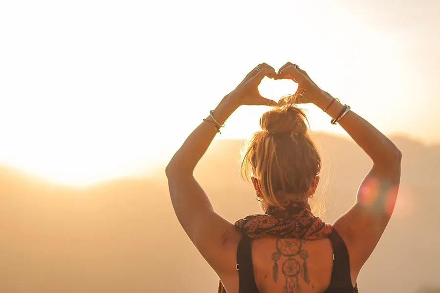 Yoga Teacher Training Courses in Rishikesh - Lady holding a heart at sunrise